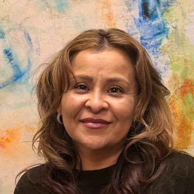 Billing Expert Erika Cervantes Smiling In Front Of Watercolor Painting