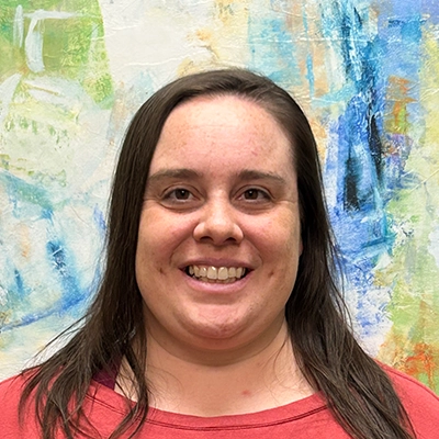 Physical Therapist Shawna Smith Smiling In Front Of Watercolor Painting